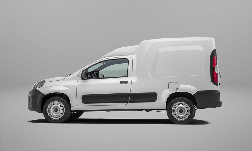 Fiat Fiorino branca vista de perfil, destacando o design lateral do furgão compacto.