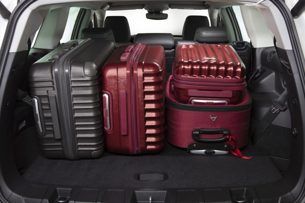 Jeep Commander branco com porta-malas aberto, mostrando amplo espaço interno para bagagens.