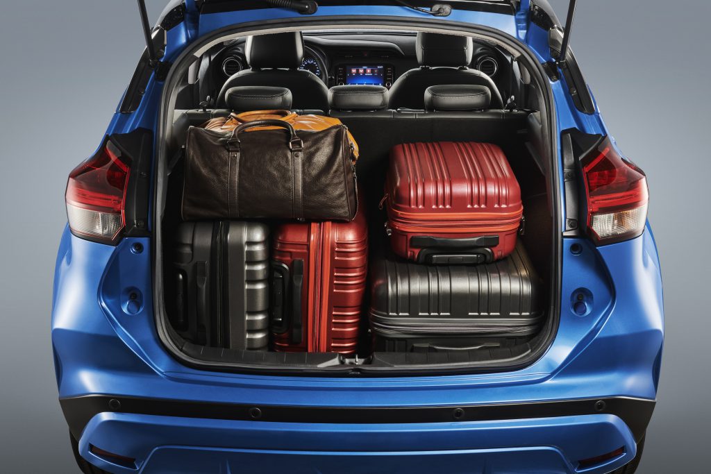 Nissan Kicks azul com porta-malas aberto, carregado de bolsas