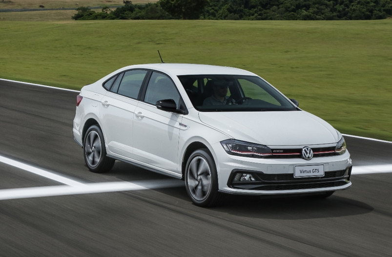 Volkswagen Virtus GTS em movimento, destacando design esportivo, rodas maiores e estilo dinâmico do sedã.