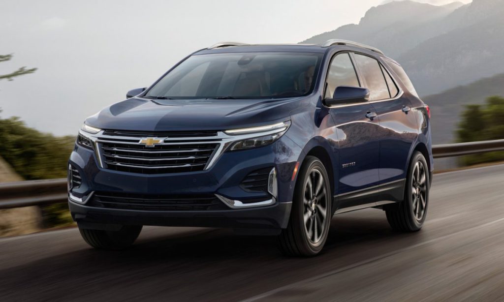 Chevrolet Equinox azul em movimento na estrada, com paisagem ao fundo e sensação de velocidade