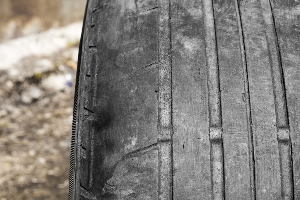 Worn tread of the car tire. The danger of using an old car tire with a small tread depth