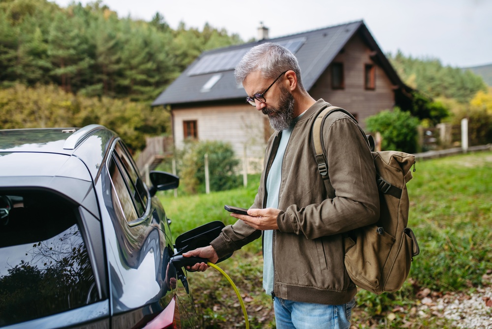 Motorista carrega o carro elétrico